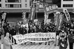決起集会で組合旗や横断幕を掲げる大阪の仲間＝３月14日、大阪市内