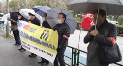 雨の中で行われたハイタク作業部会前の宣伝＝３月18日、千代田区・厚生労働省前
