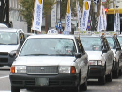 のぼり旗をたて行進するタクシーデモ＝11月24日、石川・片町