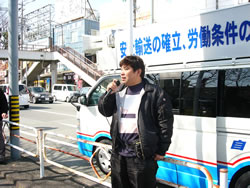 宣伝カーから訴える大阪バス部会の山本さん＝３月22日、宇治山田駅前
