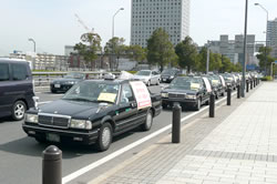 ボディーステッカーでアピールしながら車両デモを行うタクシー＝３月６日、横浜市内