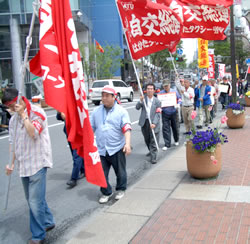 組合旗をなびかせデモ行進する福岡地連の仲間