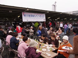 もちつき大会会場で振舞われた料理を食べる参加者＝11月６日、宮城・仙台市