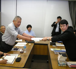 要請書を渡す飯沼委員長（左）＝６月６日、東京・厚生労働省内