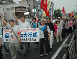 シュプレヒコールを上げながら行進する参加者＝７月４日、大阪市内