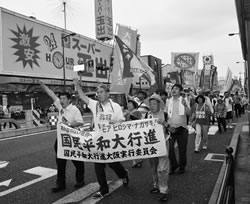 シュプレヒコールをあげながら行進する大阪の仲間と地域の人たち＝７月４日、大阪市内